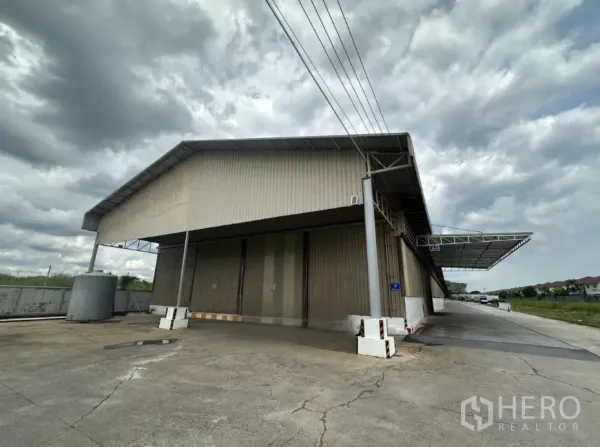 คลังสินค้า ให้เช่าในLat Krabang, Bangkok - มุมมองภายนอกโกดังผนังเมทัลชีท พร้อมหลังคาคลุมจุดขนถ่ายและถนนสำหรับรถบรรทุกในย่านลาดกระบัง