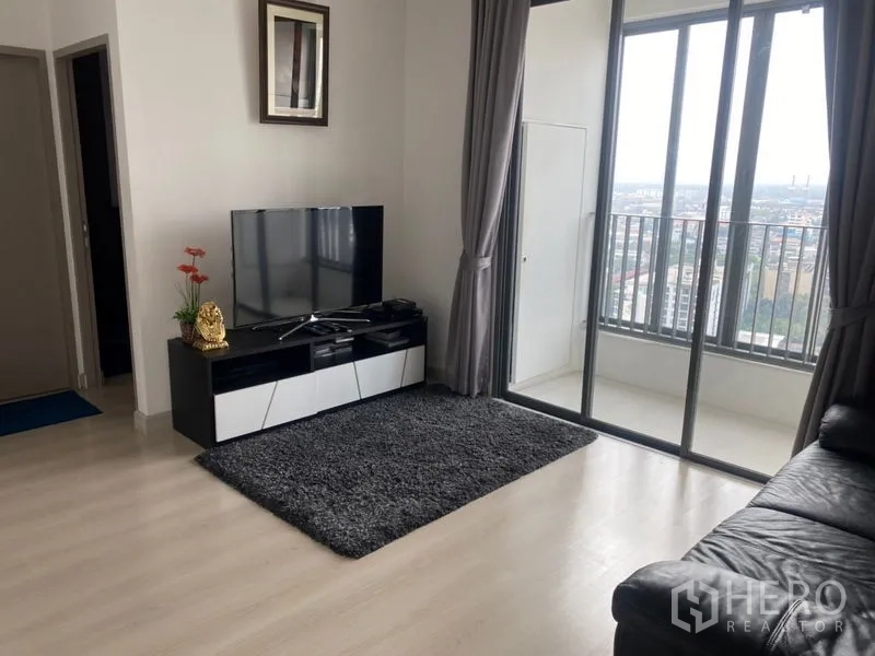 Condominium for sale in Phra Khanong, Bangkok - Living area opening to a high-floor balcony with wide city skyline views