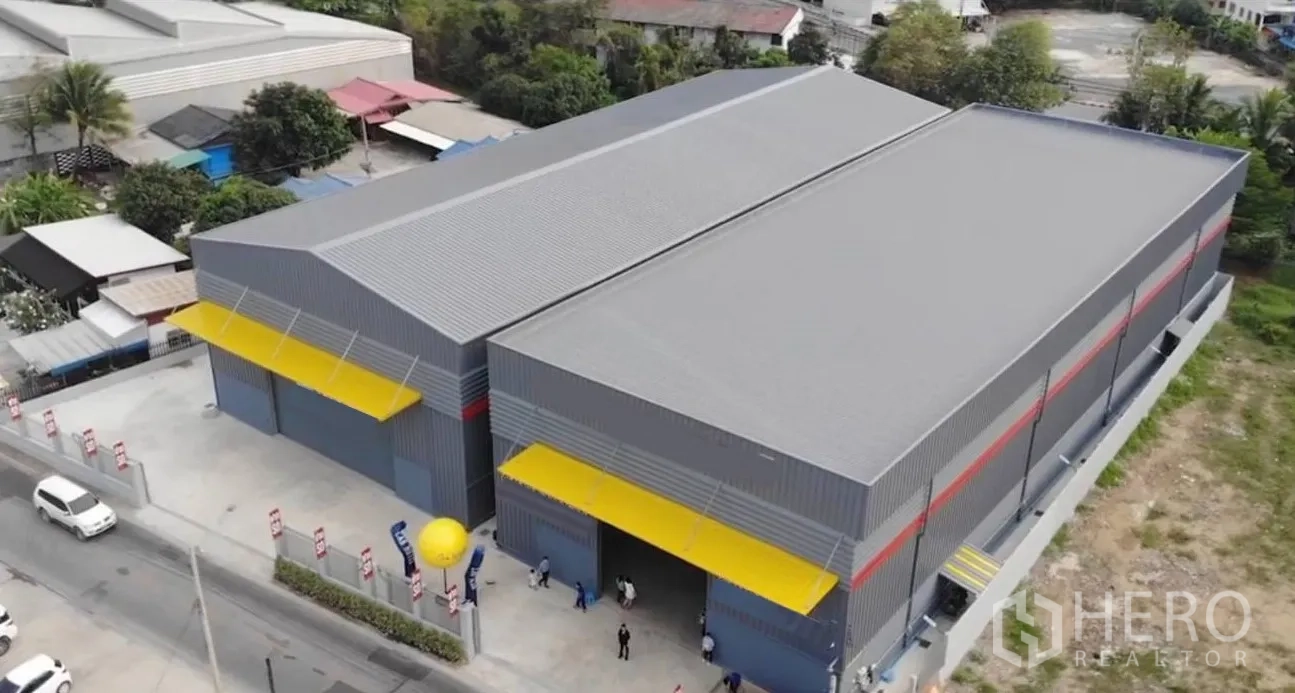 Warehouse for rent in Sai Mai, Bangkok - Aerial view of a twin-bay industrial warehouse complex with yellow canopies and fenced yard in north Bangkok.