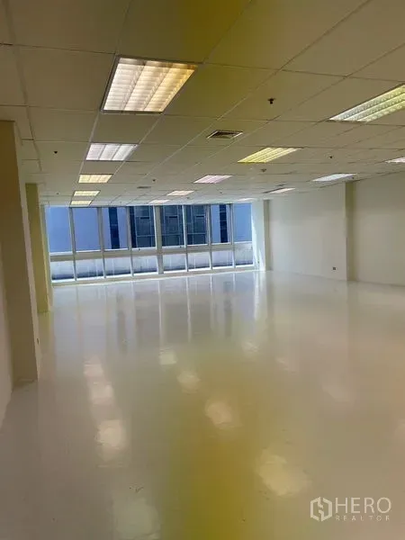 办公空间 出租在Watthana, Bangkok - 宽敞办公空间，格栅天花灯、白色地面与临城景的大窗。