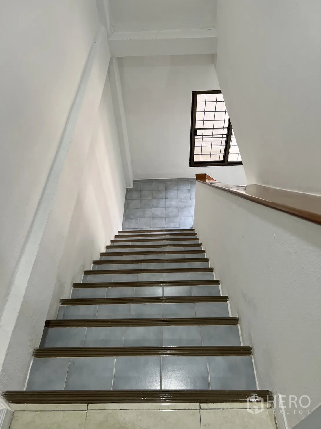 Shophouse for rent in Watthana, Bangkok - Internal stairway with wooden handrail and side window.