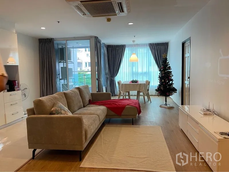 公寓 出租或出售在Watthana, Bangkok - 宽敞的客餐厅一体，推拉玻璃门通向阳台，配大面积窗户。
