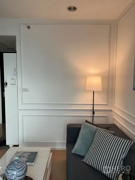 Condominium for rent or sale - Cozy living area with grey sofa, floor lamp, wall moulding and a neat coffee table.