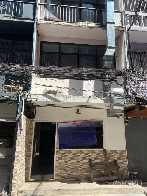 店屋 出租或出售 - 多层商住楼正立面，门前贴砖，外墙有排风管，道路上布满电缆。