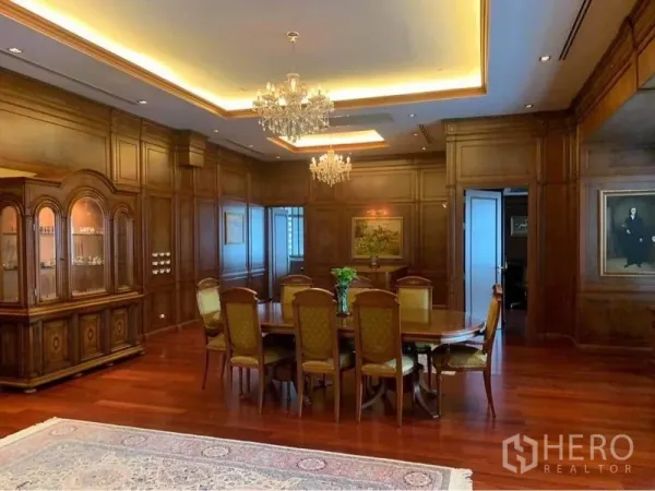 公寓 出租在Watthana, Bangkok - 正式餐厅，水晶吊灯、展示柜与椭圆餐桌，软包餐椅与木地板。