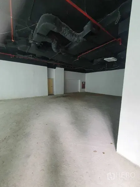 Retail Space for rent in Bang Rak, Bangkok - Spacious shell retail interior with high black ceiling and red sprinkler pipes.