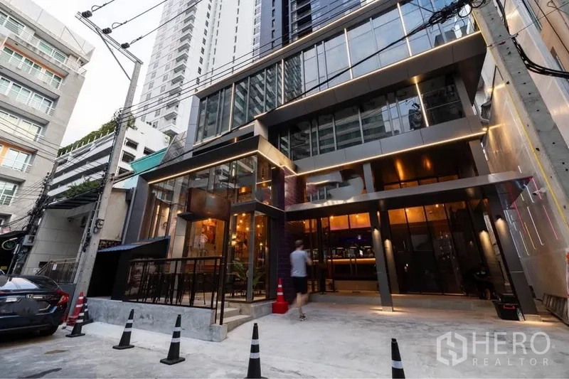 พื้นที่ขายปลีก ให้เช่าในWatthana, Bangkok - อาคารพาณิชย์ภายนอกสมัยใหม่ หน้ากระจกทั้งบาน มีเทอเรซและแสงไฟหน้าร้านยามค่ำ.