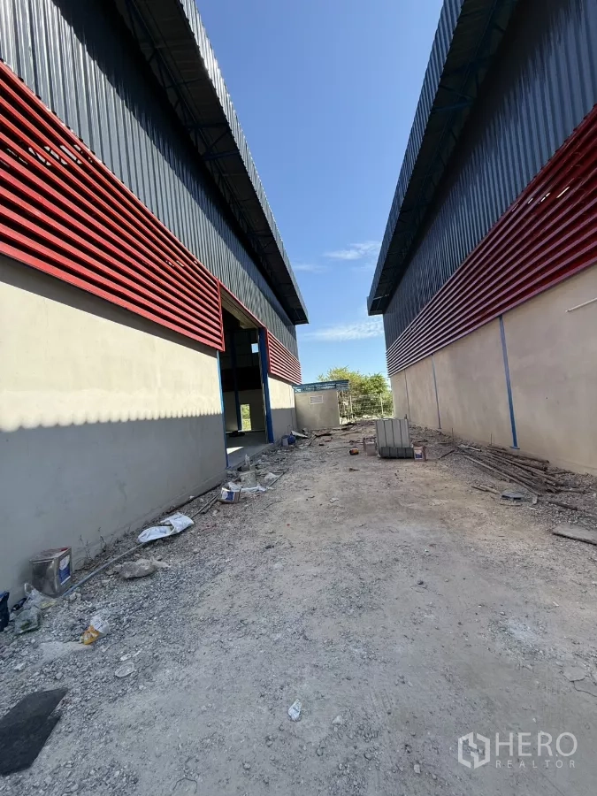 Warehouse for rent in Lam Luk Ka, Pathum Thani - Driveway between warehouse buildings with gravel surface for easy truck access.