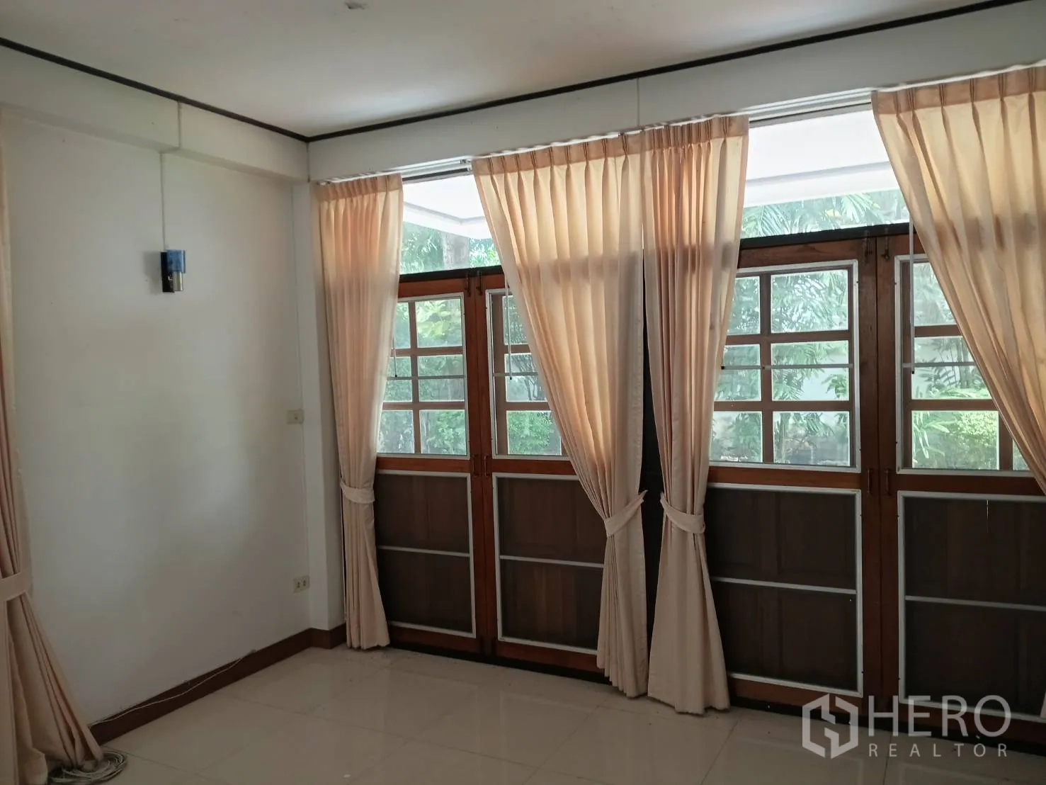 独栋房屋 for sale in Watthana, Bangkok - 明亮房间配落地木质法式门与浅色窗帘。