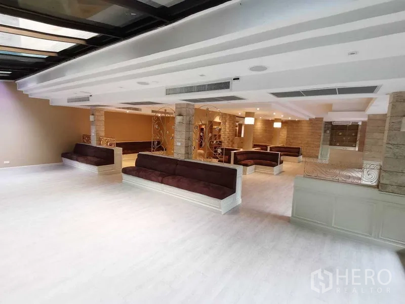 Retail Space for rent in Pathum Wan, Bangkok - Spacious open-plan hall with built-in booth seating, tray ceiling and warm lighting.
