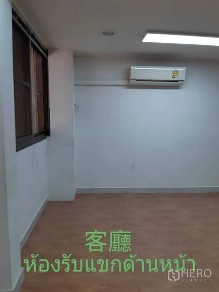 Townhouse for rent in Watthana, Bangkok - Three‑storey townhouse exterior with red gate and balcony windows.