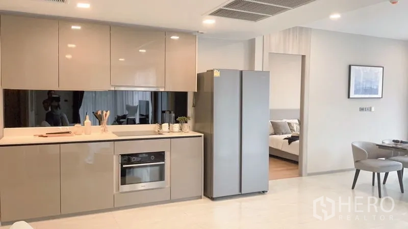 公寓 出租在Watthana, Bangkok - 现代厨房带亮面柜体、嵌入式烤箱、对开门冰箱，旁通卧室。