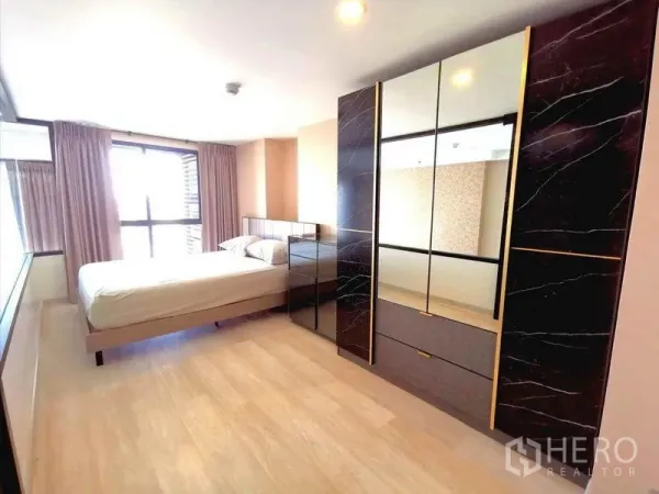 公寓 出租在Sathon, Bangkok - 明亮卧室，带大面积镜面衣柜、浅色木地板和带窗帘的宽窗。