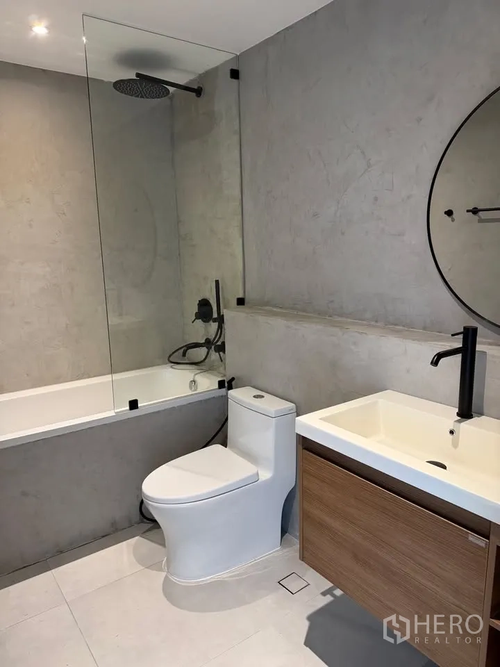 公寓 for rent in Watthana, Bangkok - 浴室配浴缸、玻璃隔断、雨淋花洒与木质洗手台。