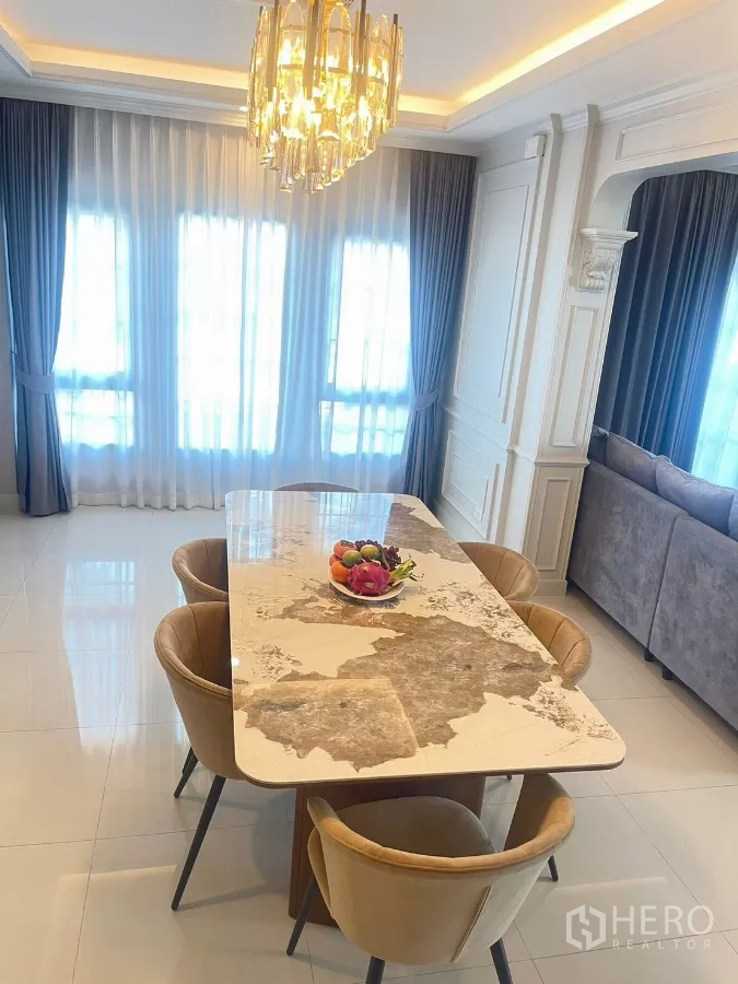 Detached House for rent in Bang Phli, Samut Prakan - Marble dining table under crystal chandelier beside full-height drapes.