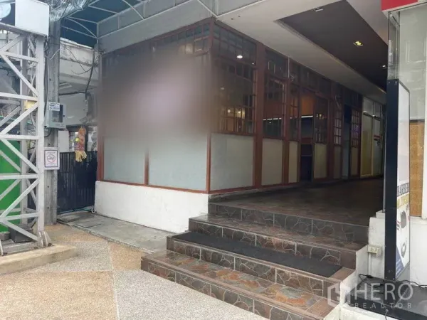 Retail Space for rent in Watthana, Bangkok - Entrance steps leading to a corner retail unit with lattice-glass facade under an awning in Phrom Phong.