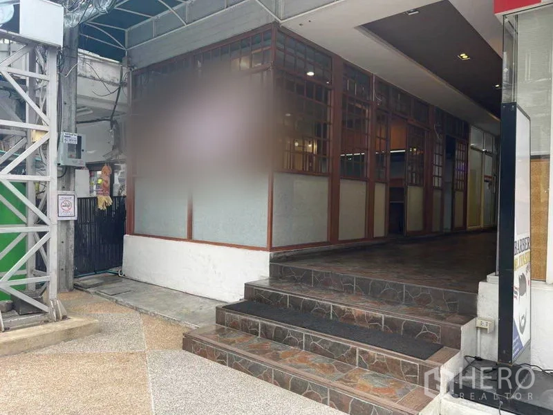 Retail Space for rent in Watthana, Bangkok - Entrance steps leading to a corner retail unit with lattice-glass facade under an awning in Phrom Phong.