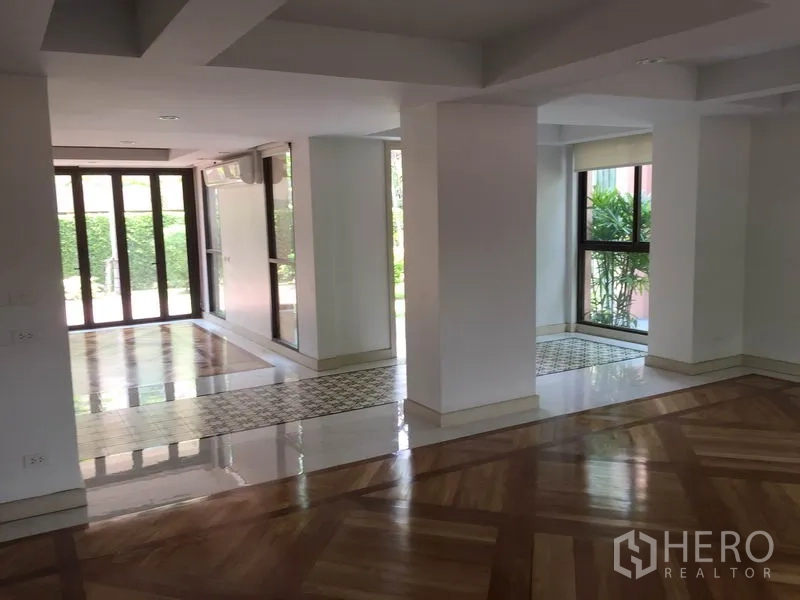 独立式住宅 出租在Sathon, Bangkok - 采光充足的开放式起居区，大窗与立柱，木地板与瓷砖相间