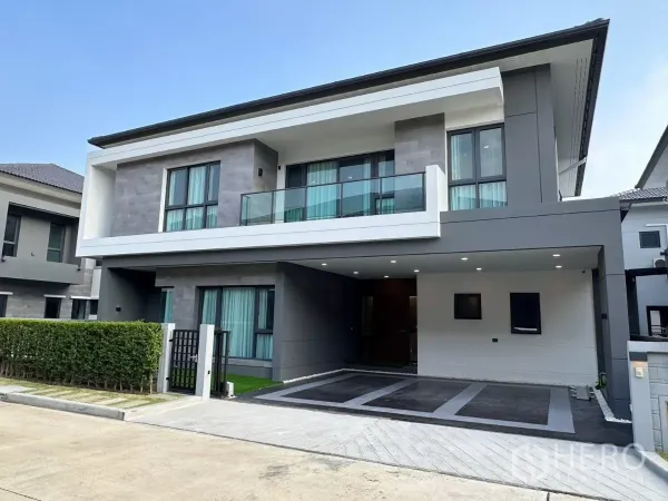 Detached House for rent in Bang Phli, Samut Prakan - Modern two-storey detached house facade in Bang Phli with balcony, carport, and grey-white cladding.