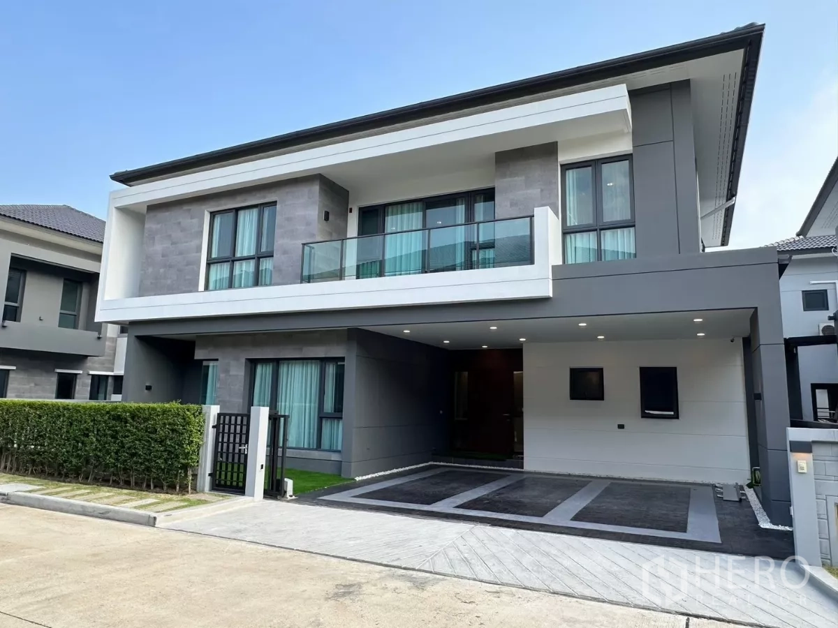 独立式住宅 出租在Bang Phli, Samut Prakan - 现代两层独栋别墅外观，带阳台与遮顶车位，灰白立面。