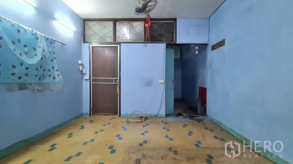 店屋 出租或出售在Watthana, Bangkok - 空置蓝墙起居区，面向房门与小走廊。