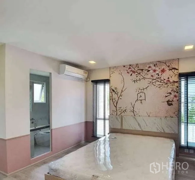 独立式住宅 出租在Prawet, Bangkok - 主卧带花卉特色墙，套卫入口与落地窗。