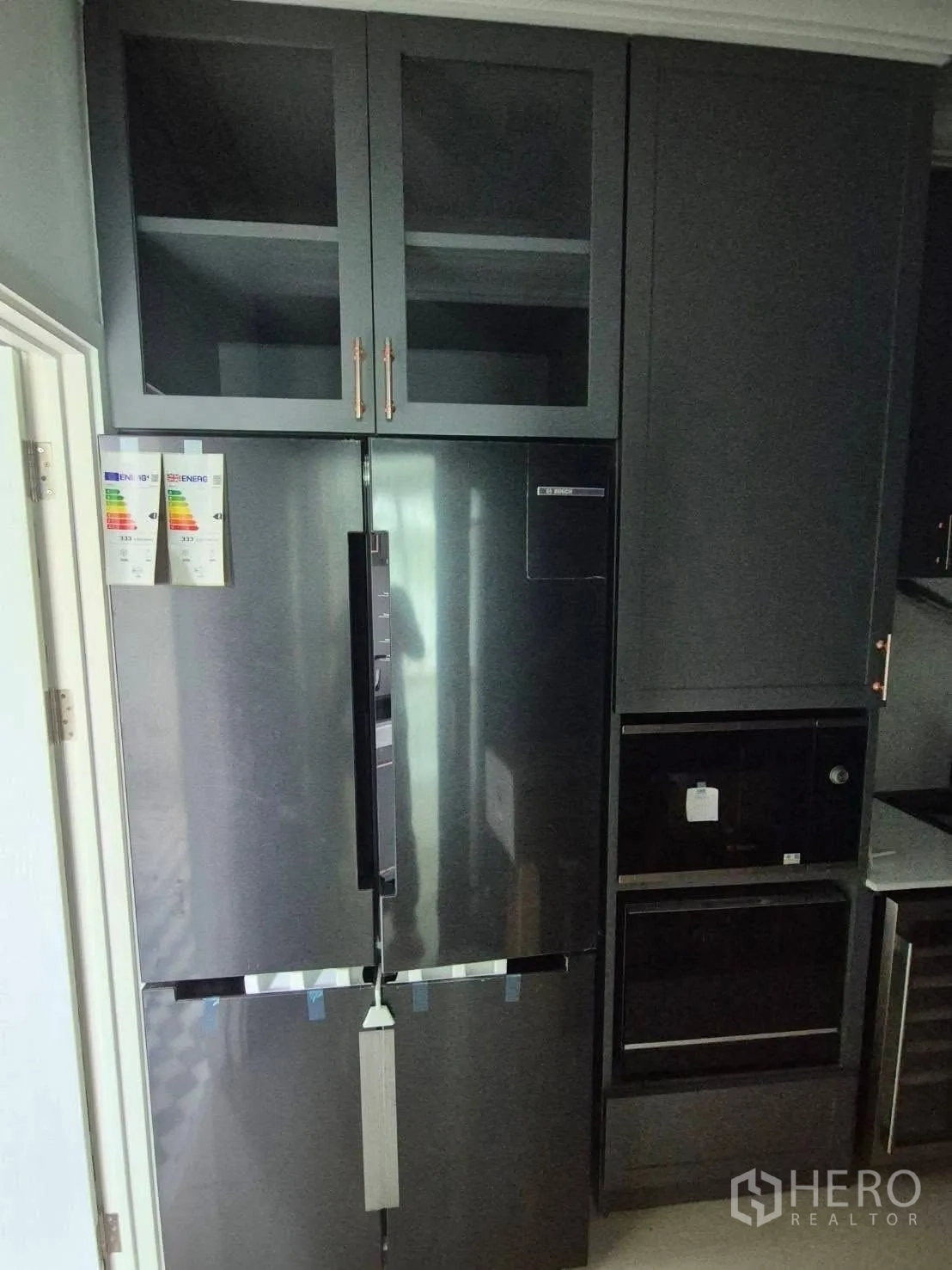 Detached House for sale in Bang Kruai, Nonthaburi - Tall dark refrigerator with built‑in ovens and storage cabinetry.