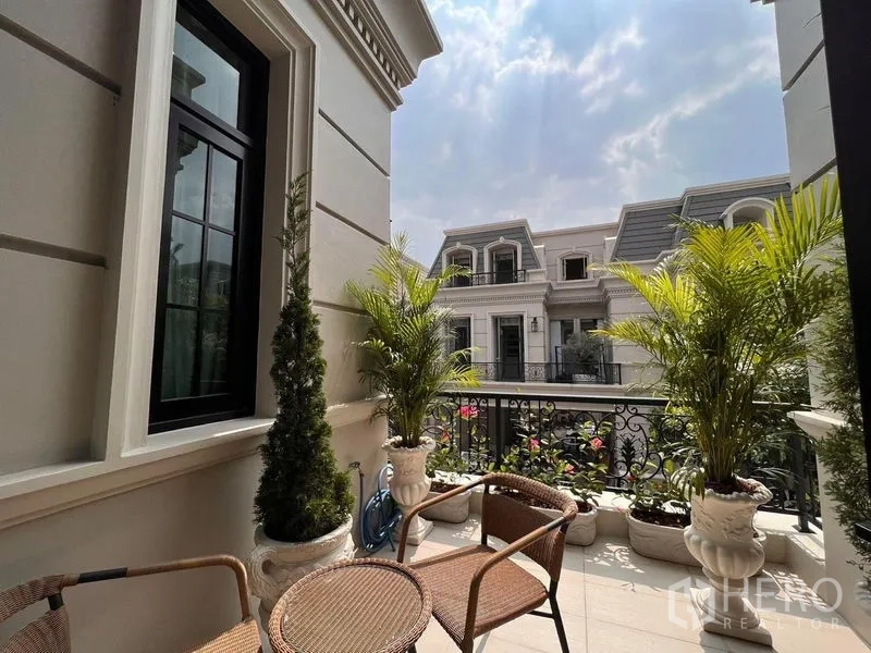 Detached House for sale in Yan Nawa, Bangkok - Sunny balcony terrace with potted plants, seating and views of neighboring homes.