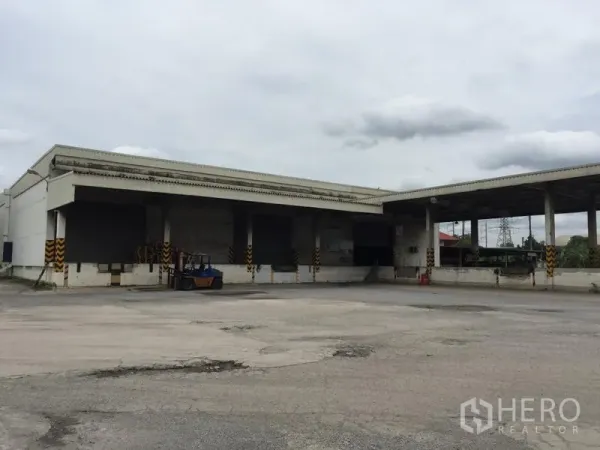 Warehouse for rent in Pathum Thani - Warehouse exterior showing covered loading bays, wide driveway, and forklift-friendly yard.