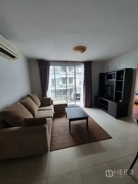 Condominium for rent in Yan Nawa, Bangkok - Bright living room with sofa, coffee table and TV unit opening to a balcony in a Bangkok condo.