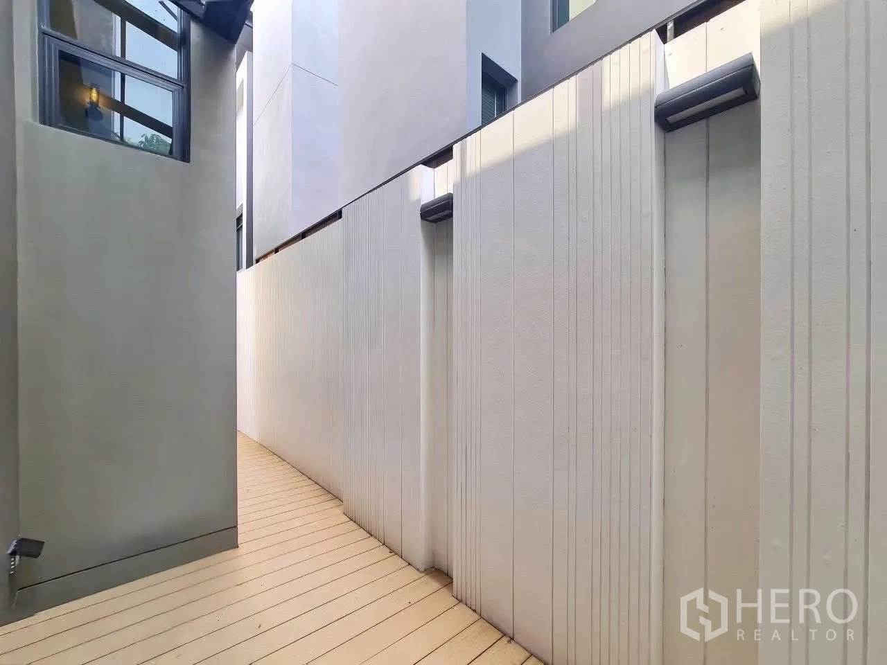 独栋房屋 for rent in Phra Khanong, Bangkok - 独栋住宅侧边走道，高隐私围墙与浅色露台地板。