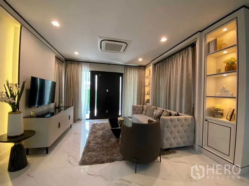 บ้าน ให้เช่าในBang Khen, Bangkok - ห้องนั่งเล่นสมัยใหม่ ผนังทีวี ชั้นโชว์บิวท์อิน และผ้าม่านเต็มผนัง