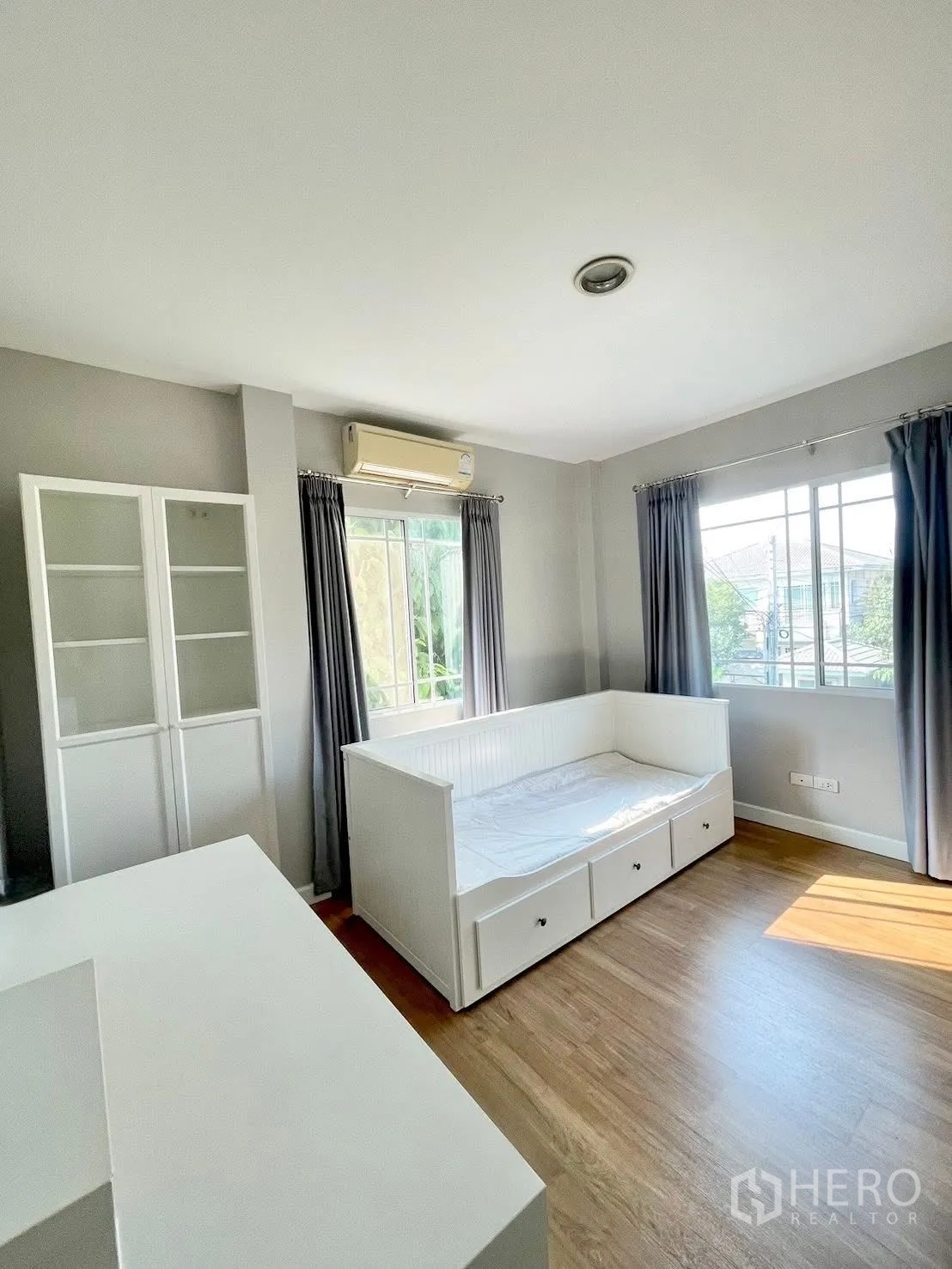 บ้านเดี่ยว for rent in Prawet, Bangkok - ห้องเอนกประสงค์มีเตียงเดย์เบดสีขาว ตู้กระจก และเครื่องปรับอากาศ