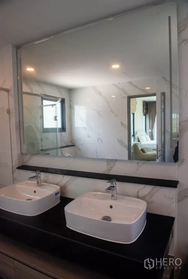 Detached House for rent in Bang Phli, Samut Prakan - Double washbasins beneath a full-width mirror in a bright bathroom.