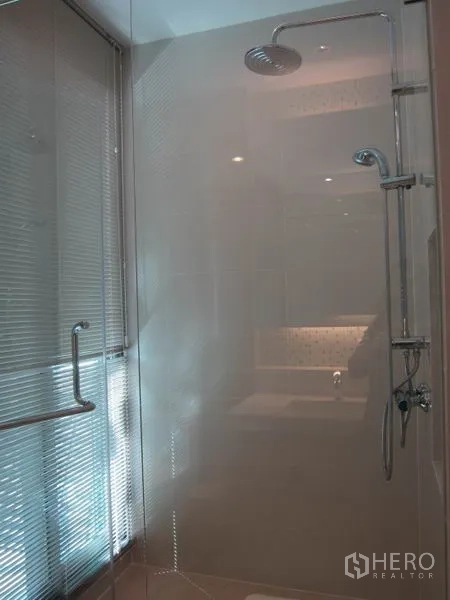 Condominium for rent in Khlong Toei, Bangkok - Glass-enclosed shower with rain showerhead and handheld sprayer.