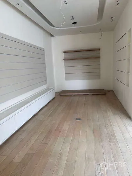 Standalone for rent in Khlong Toei, Bangkok - Compact room with slat display panels and light wood flooring for retail or office use.