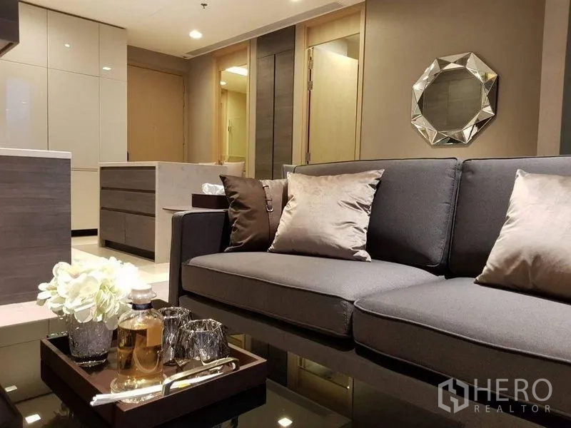 คอนโด ให้เช่าในWatthana, Bangkok - โซฟาพร้อมหมอนอิงและถาดของตกแต่งบนโต๊ะกลางผิวเงา