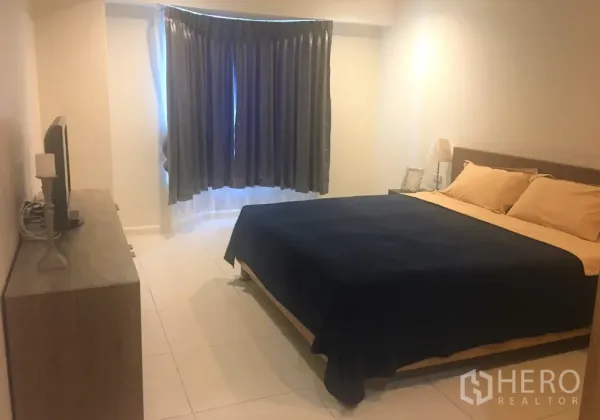 公寓 出租在Watthana, Bangkok - 主卧配特大床、斗柜与电视，飘窗配窗帘。