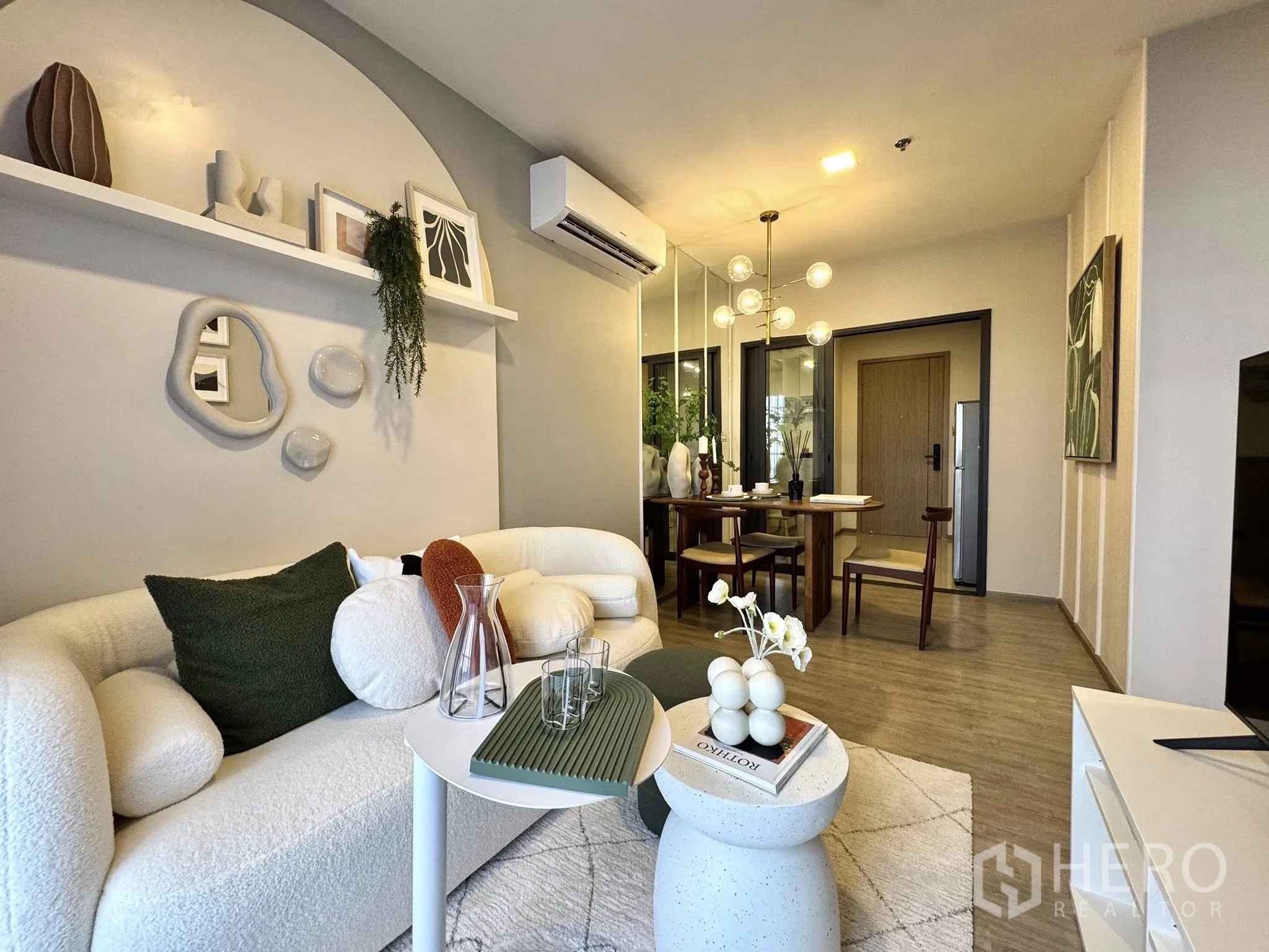 Condominium for rent in Watthana, Bangkok - View from sofa to dining area and entry, decorative shelf and modern lighting.