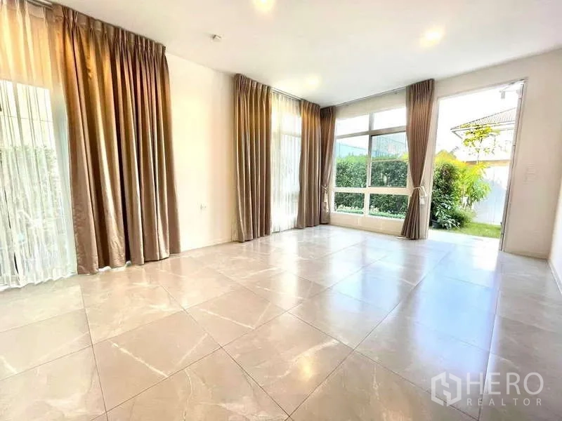Detached House for rent in Prawet, Bangkok - Open-plan living space with multiple tall windows, tiled floors and garden views.