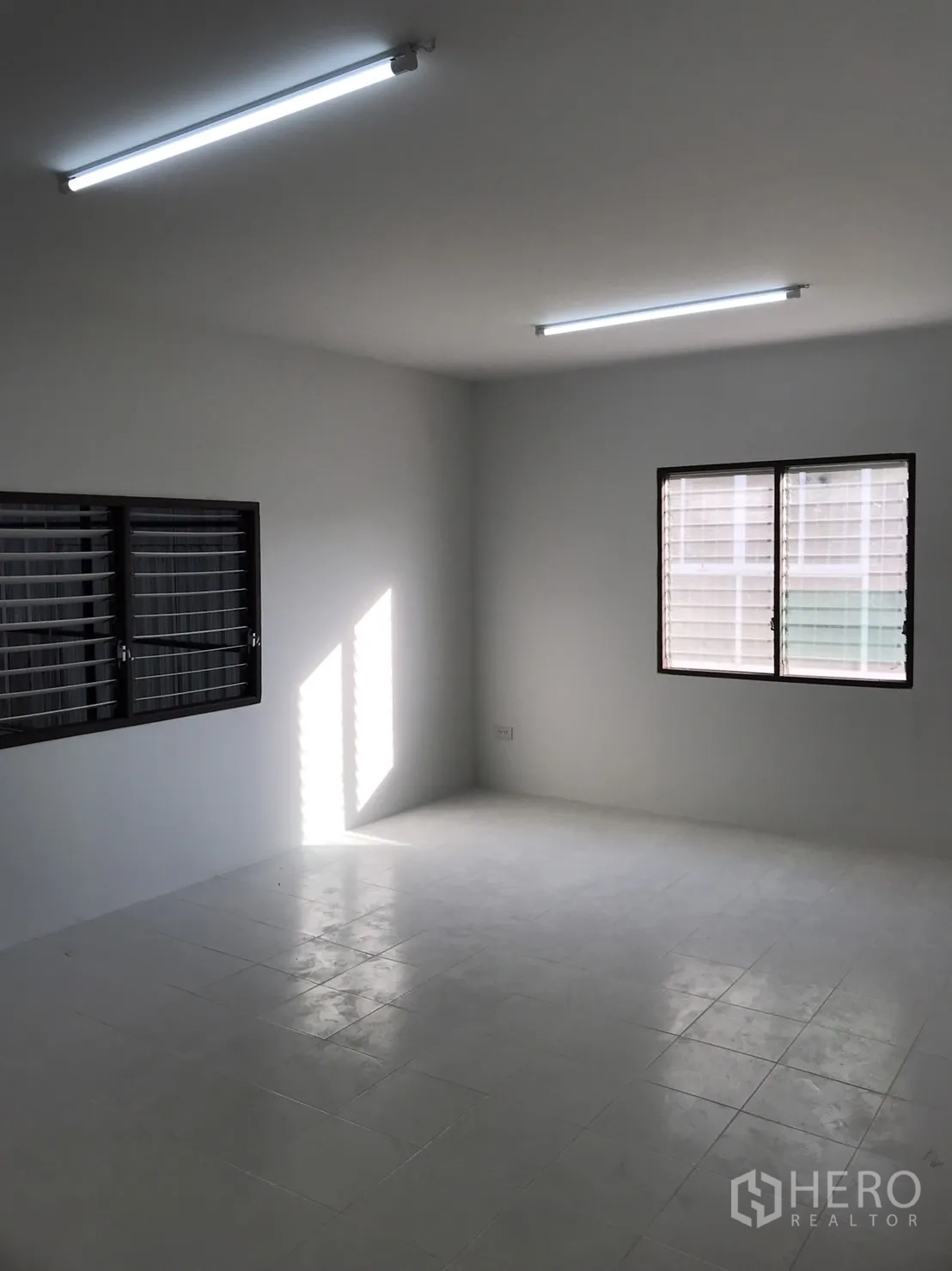 Warehouse for rent in Lam Luk Ka, Pathum Thani - Bright tiled office room with windows and LED strip lights.