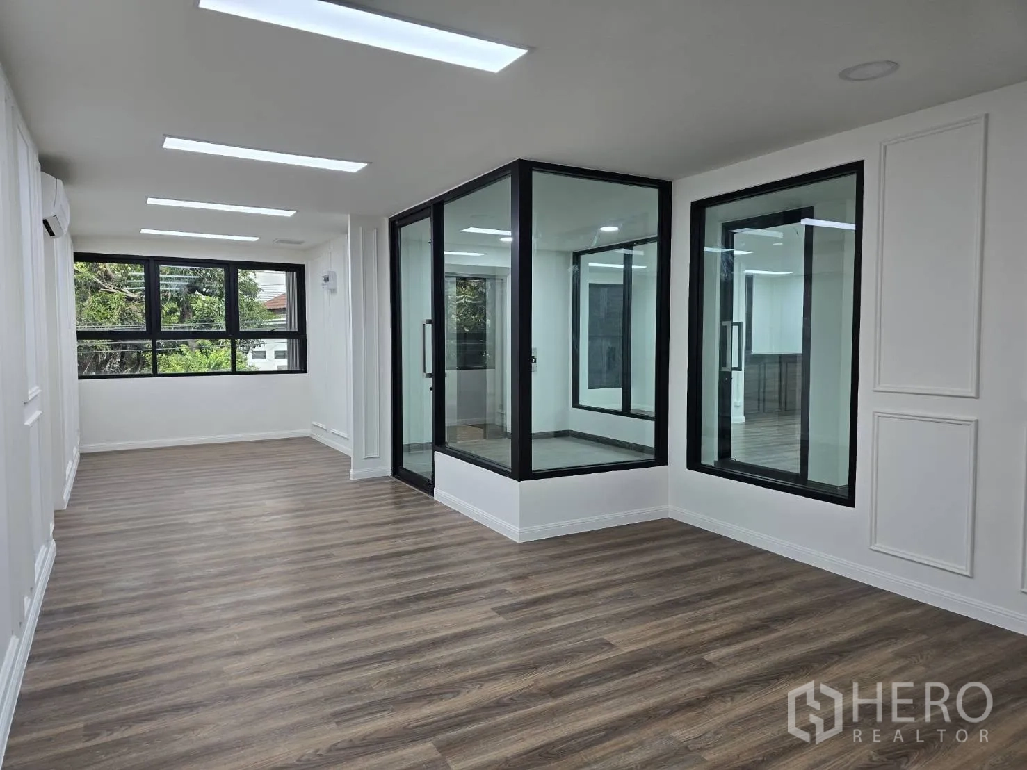 Home Office for rent in Chatuchak, Bangkok - Bright office room with wood-style floors, LED ceiling lights and a glass meeting room.