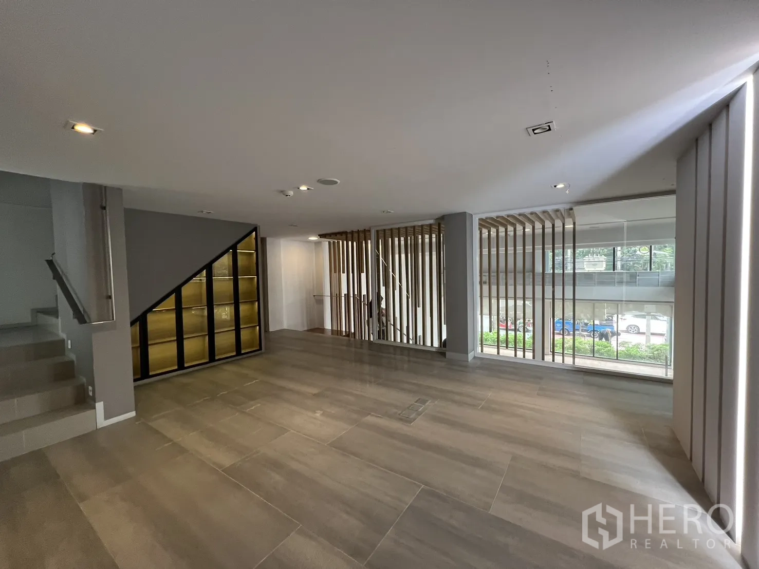 Retail Space for rent in Khlong Toei, Bangkok - Mezzanine lounge with large tiles, stair and illuminated display cabinet.