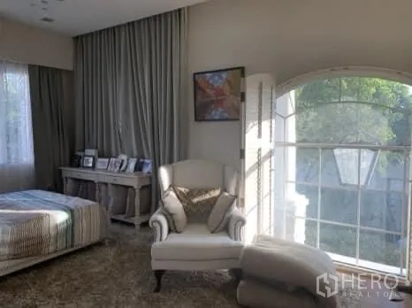 Detached House for sale in Bang Phli, Samut Prakan - Sunlit sitting corner with an arched window, armchair, and desk adjacent to a bedroom.