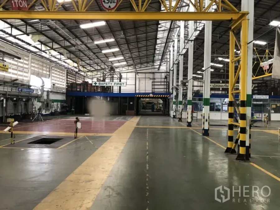 工厂 出租在Lam Luk Ka, Pathum Thani - 主通道宽阔，黄色行车梁上方，警示条纹立柱与通风百叶墙体。