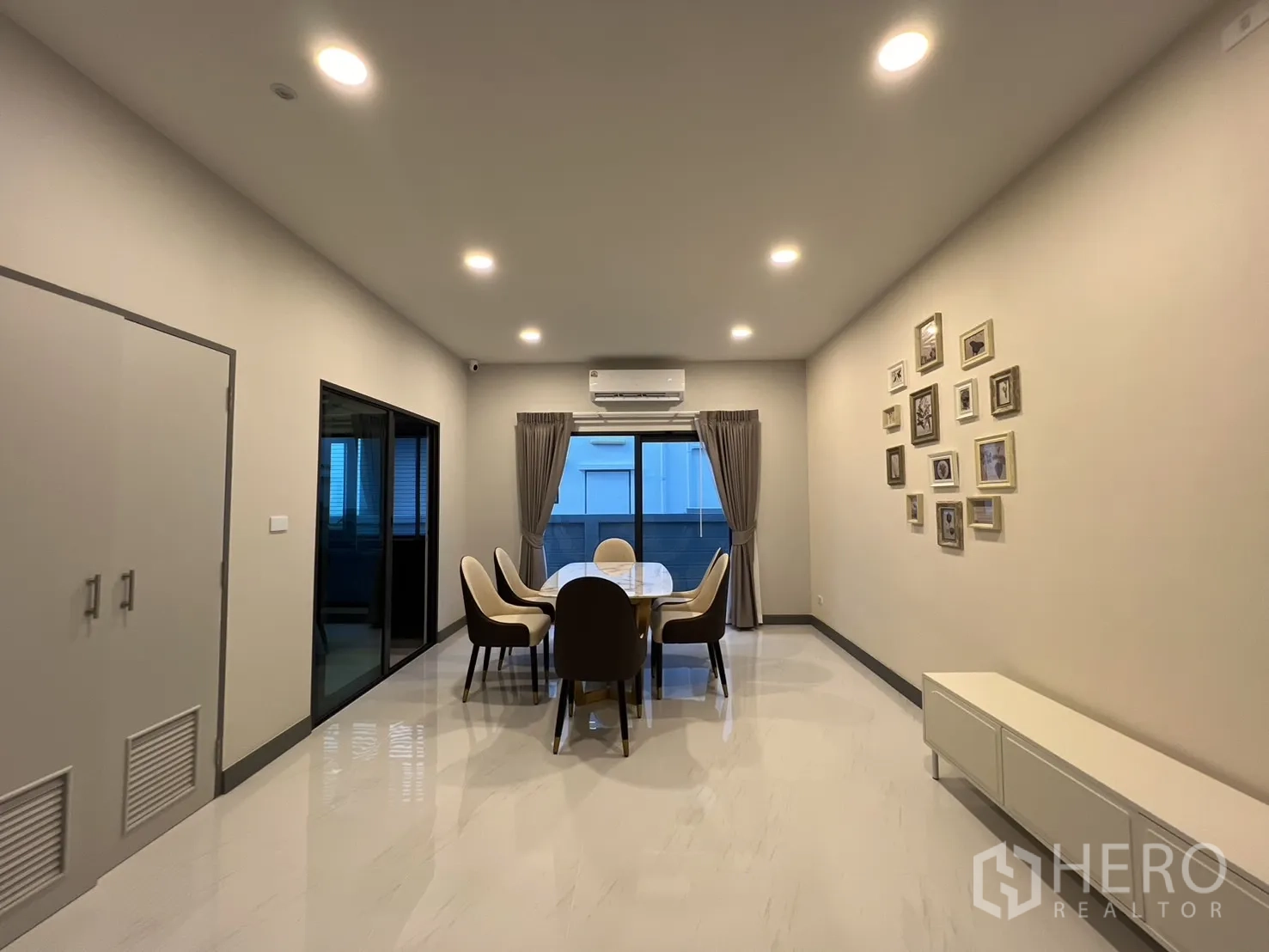 Detached House for rent in Bang Phli, Samut Prakan - Dining room with six-seat table, sliding glass doors and recessed lighting.