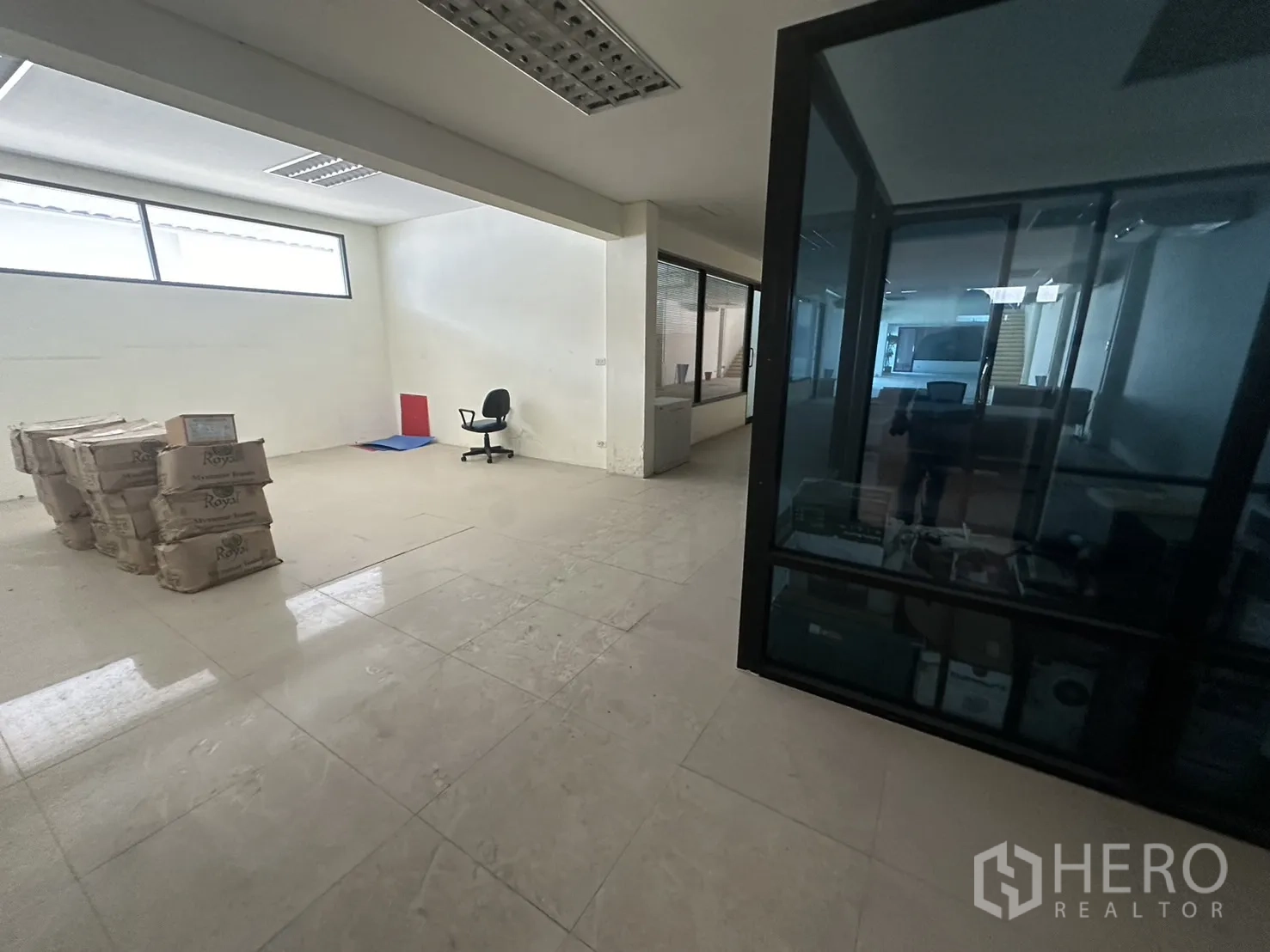 Factory for rent or sale in Prawet, Bangkok - Office workspace with glass-partitioned room and open area for workstations.