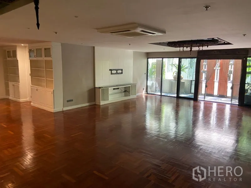 公寓 出售在Khlong San, Bangkok - 明亮客厅，内置电视柜，落地推拉门通往绿意阳台。