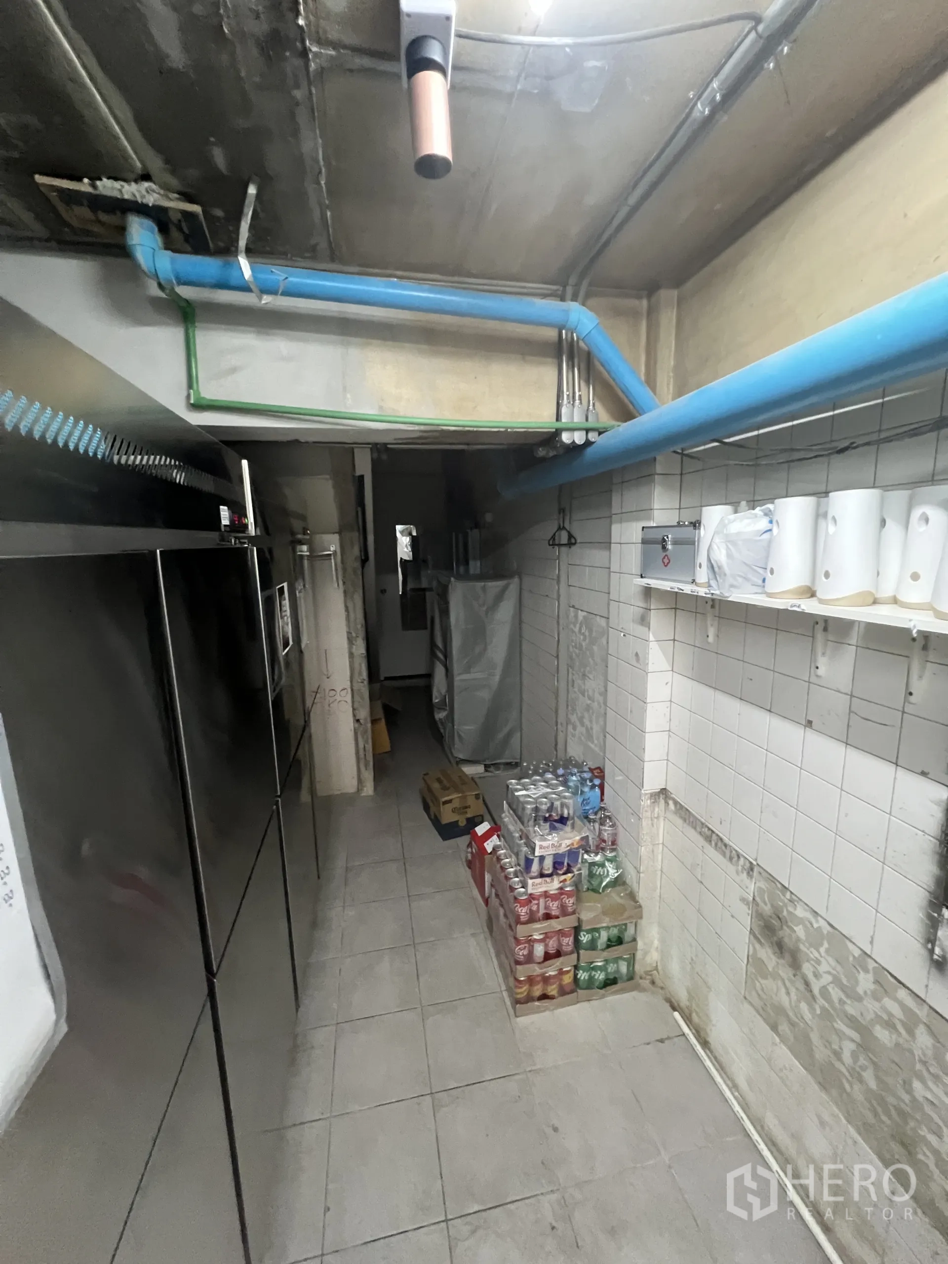 零售空间 出租在Watthana, Bangkok - 储物走廊，冰箱、外露管线与堆放饮料。