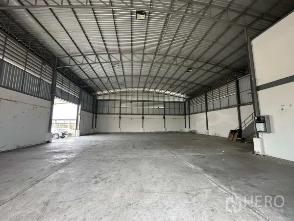 โรงงาน ให้เช่าในPathum Thani - มุมมองภายในไปยังผนังด้านหลัง มีประตูทางออกด้านข้างและบันไดเหล็ก